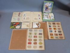 A collection of matchbox lids and cigarette cards in hardback albums and paperback books.