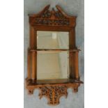 A Victorian walnut pier mirror with fret carved cornice and open shelves fitted with original