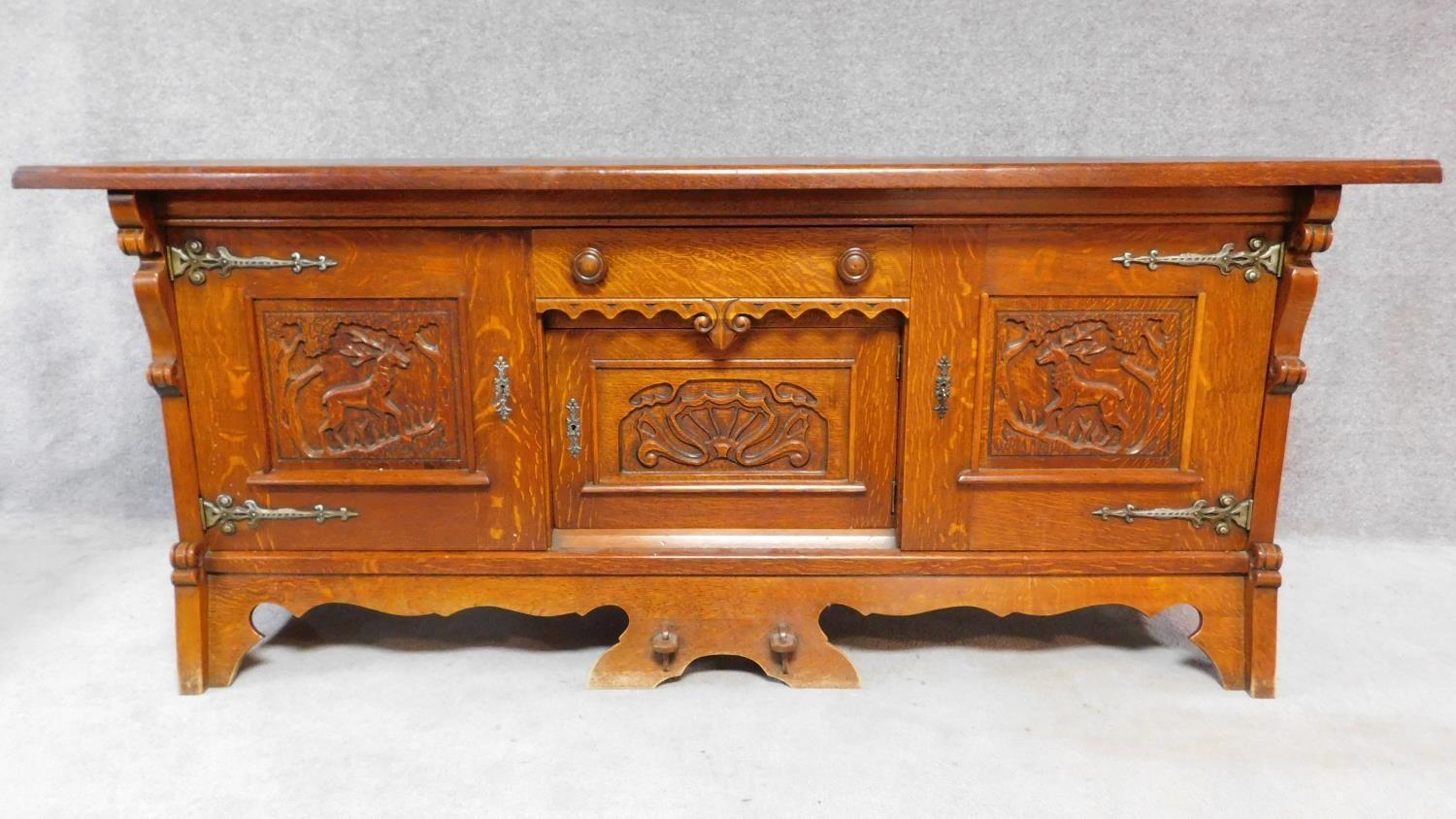 A mid 20th century Continental carved oak sideboard decorated with animal and scroll work
