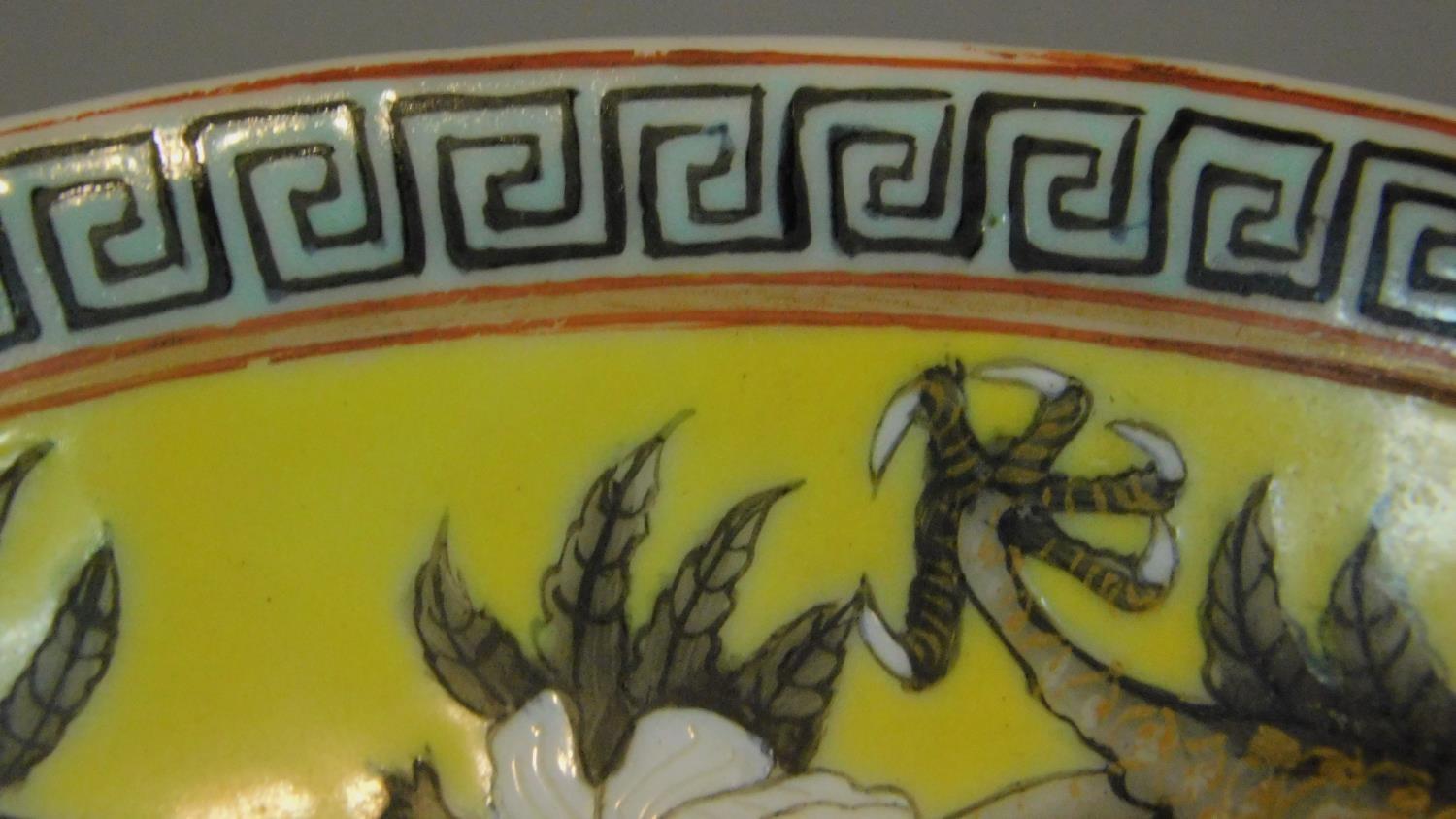 A Chinese yellow ground ceramic dish depicting two dragons, one red and one black. Greek key pattern - Image 6 of 6