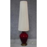 A tall vintage floor standing or table lamp of bulbous glazed form on gilt metal base. H.140cm