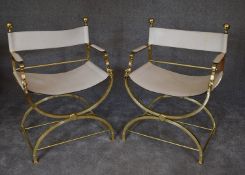 A pair of brass X framed Romanesque armchairs with cream leather upholstery. H.87 x 63cm