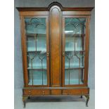 An Edwardian mahogany display cabinet with astragal glazed doors above base drawers on cabriole