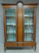 An Edwardian mahogany display cabinet with astragal glazed doors above base drawers on cabriole