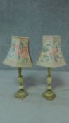 Two lamps with floral decorated shades and turned porcelain and brass supports. H.70cm