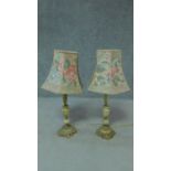 Two lamps with floral decorated shades and turned porcelain and brass supports. H.70cm