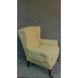 A lemon upholstered Edwardian beech framed wing back armchair. H.103cm