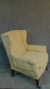 A lemon upholstered Edwardian beech framed wing back armchair. H.103cm