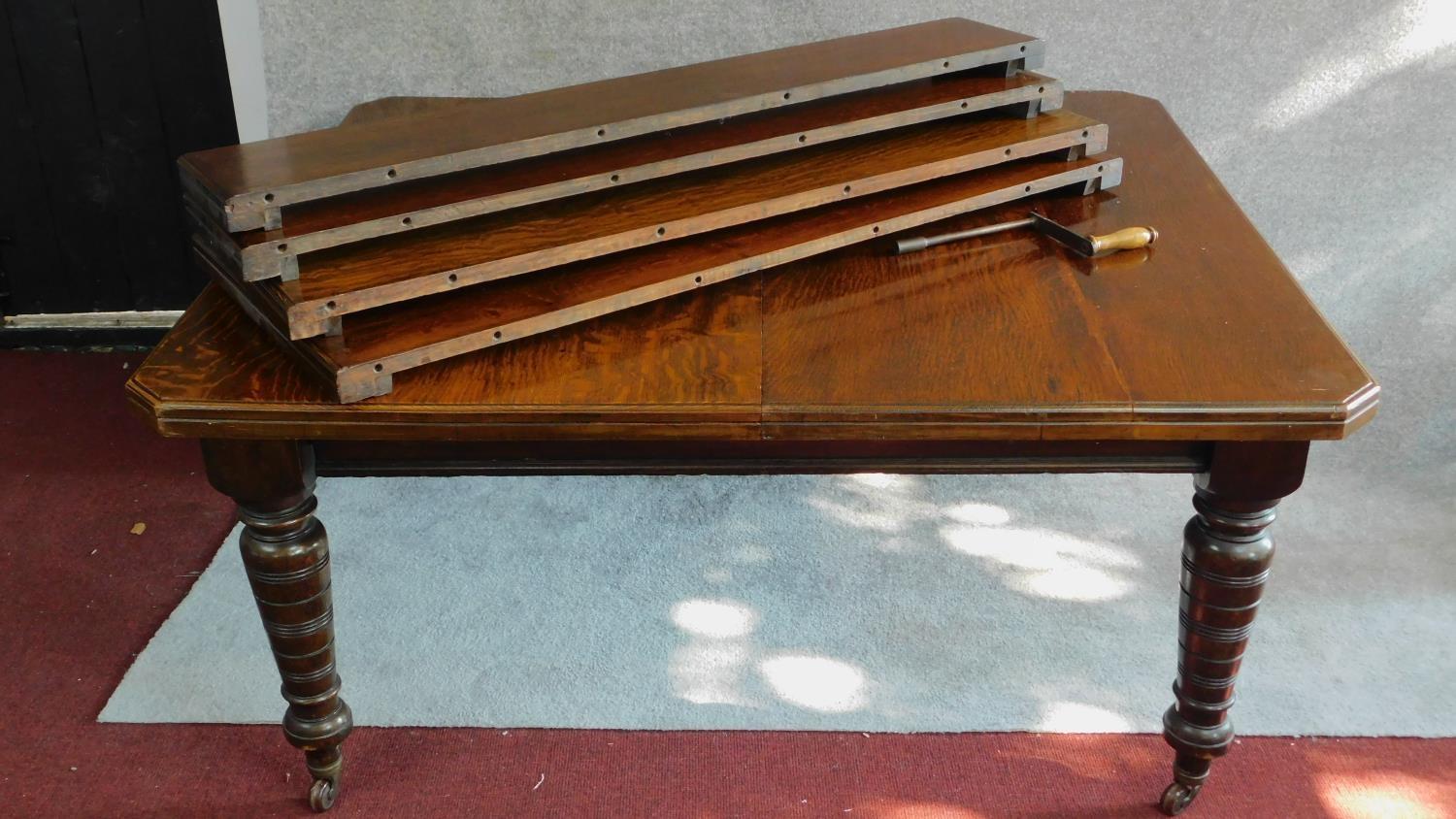 A late Victorian oak extending dining table with four extra leaves on turned tapering supports. H.75 - Image 4 of 6