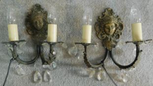 A pair of brass wall lights with crystal drops and Art Noveau style masks to back. H.30 W.26cm