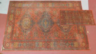 A Tabriz style rug with triple pendant medallion on a rouge field with repeating geometric