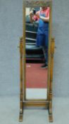 A Jacobean style Ipswich oak cheval mirror with carved toprail and brass adjusting handles. 143x45cm