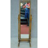 A Jacobean style Ipswich oak cheval mirror with carved toprail and brass adjusting handles. 143x45cm