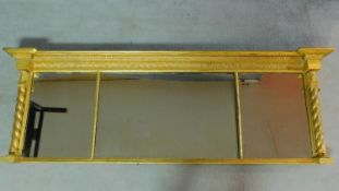 A Regency carved giltwood overmantel mirror with triple central plates flanked by Egyptian style