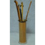 Six wooden canes, one with metal handle in a brass umbrella stand. H.90 (tallest cane)