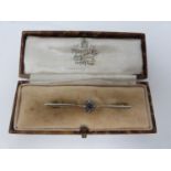 A diamond and sapphire 15 carat gold bar brooch, set to centre with a round old cut sapphire with an