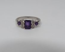 An Amethyst and diamond 18ct white gold ring, set to centre with a emerald cut amethyst in a four