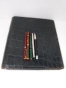 A collection of vintage fountain pens and a crocodile leather travel stationery case. Pens include