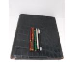 A collection of vintage fountain pens and a crocodile leather travel stationery case. Pens include