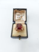 A yellow metal and hessonite garnet cocktail ring, set to centre with an rectangular mixed cut