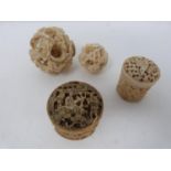 Two Chinese carved ivory puzzle balls and two oriental carved trinket boxes, one ivory and one bone.