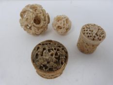 Two Chinese carved ivory puzzle balls and two oriental carved trinket boxes, one ivory and one bone.