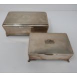 A pair of wooden lined silver cigarette boxes, the larger one with engine turned decoration and