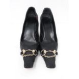A pair of GUCCI stiletto heels, with gold stirrup and chain detailing on the front. GUCCI print