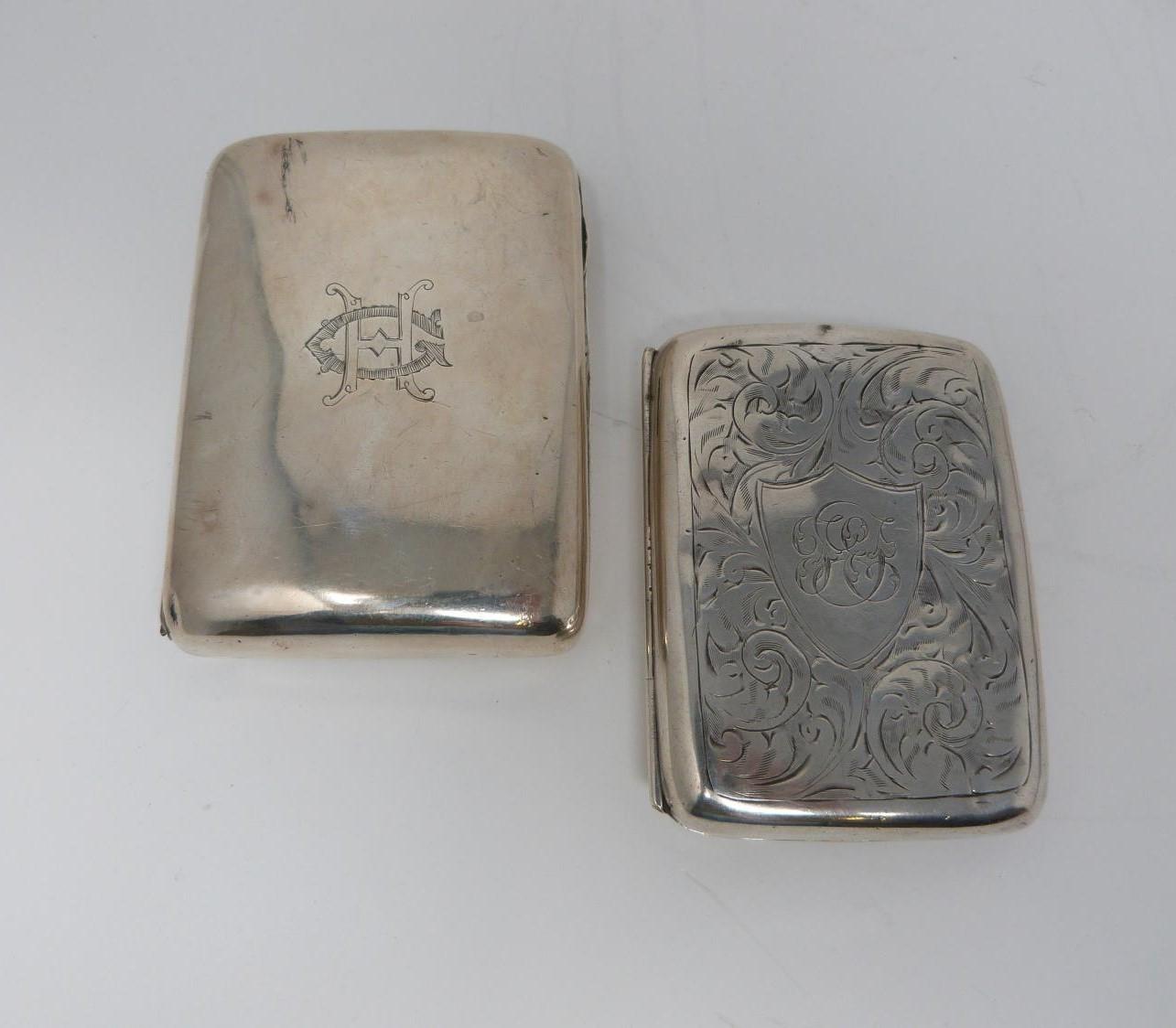 Two silver cigarette cases, the smaller with stylised foliate decoration and central shield