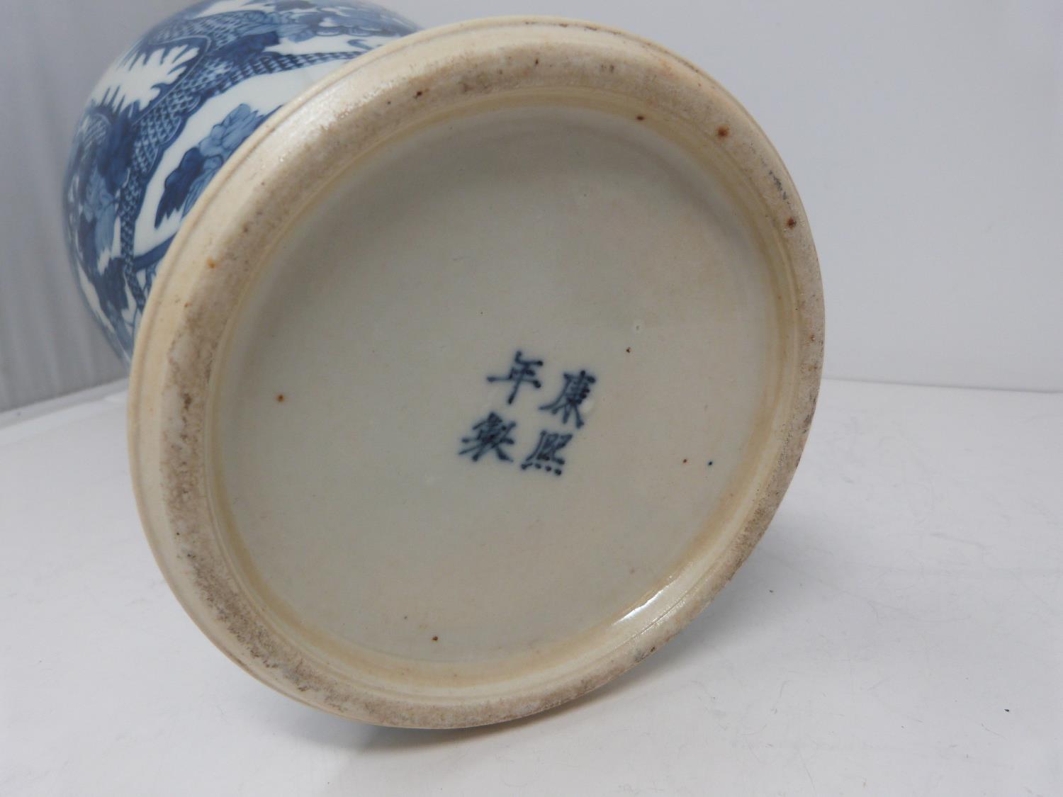 A Kangxi style blue and white baluster dragon vase with floral motifs. Four character mark to - Image 4 of 5