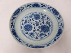 A Chinese blue and white porcelain saucer dish with foliate scroll and floral decoration, six-