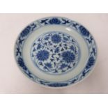 A Chinese blue and white porcelain saucer dish with foliate scroll and floral decoration, six-