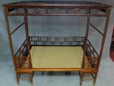 A Chinese hardwood four poster bedframe with woven base and pierced fretwork canopy. H.201 W.105 D.