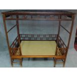 A Chinese hardwood four poster bedframe with woven base and pierced fretwork canopy. H.201 W.105 D.