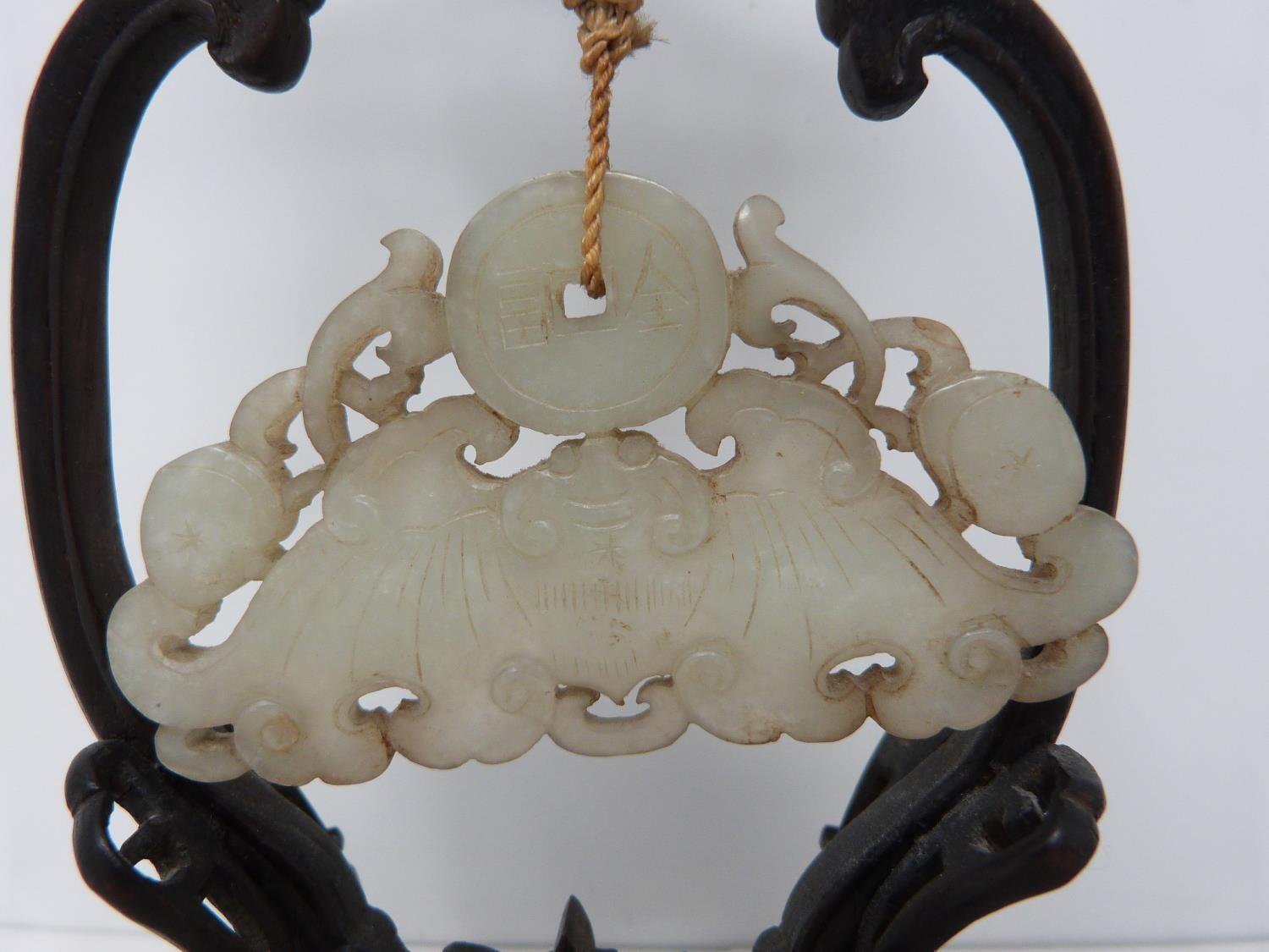 An early 20th century jade pendant on carved wooden stand. Pale celadon jade pendant in the form - Image 2 of 6