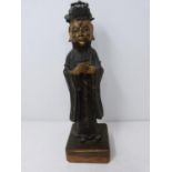 An antique bronze Chinese statue of a deity with traces of gilding on the face and hands. Mounted on