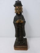 An antique bronze Chinese statue of a deity with traces of gilding on the face and hands. Mounted on