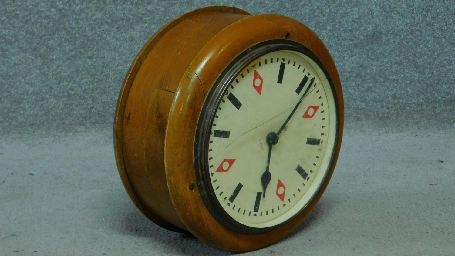 A King George V G.P.O. wooden cased 10" double-sided electric slave dial wall clock within turned