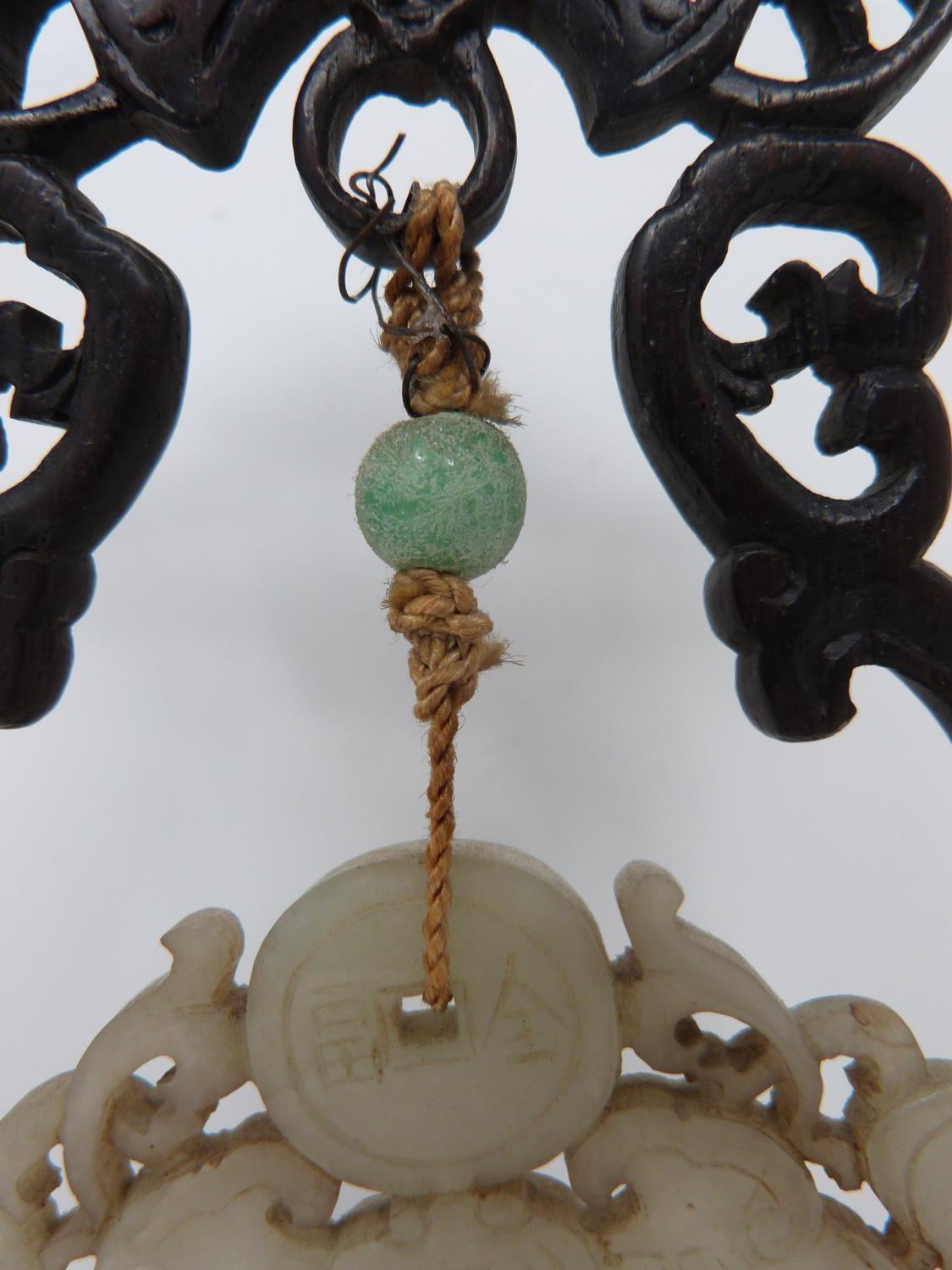 An early 20th century jade pendant on carved wooden stand. Pale celadon jade pendant in the form - Image 3 of 6