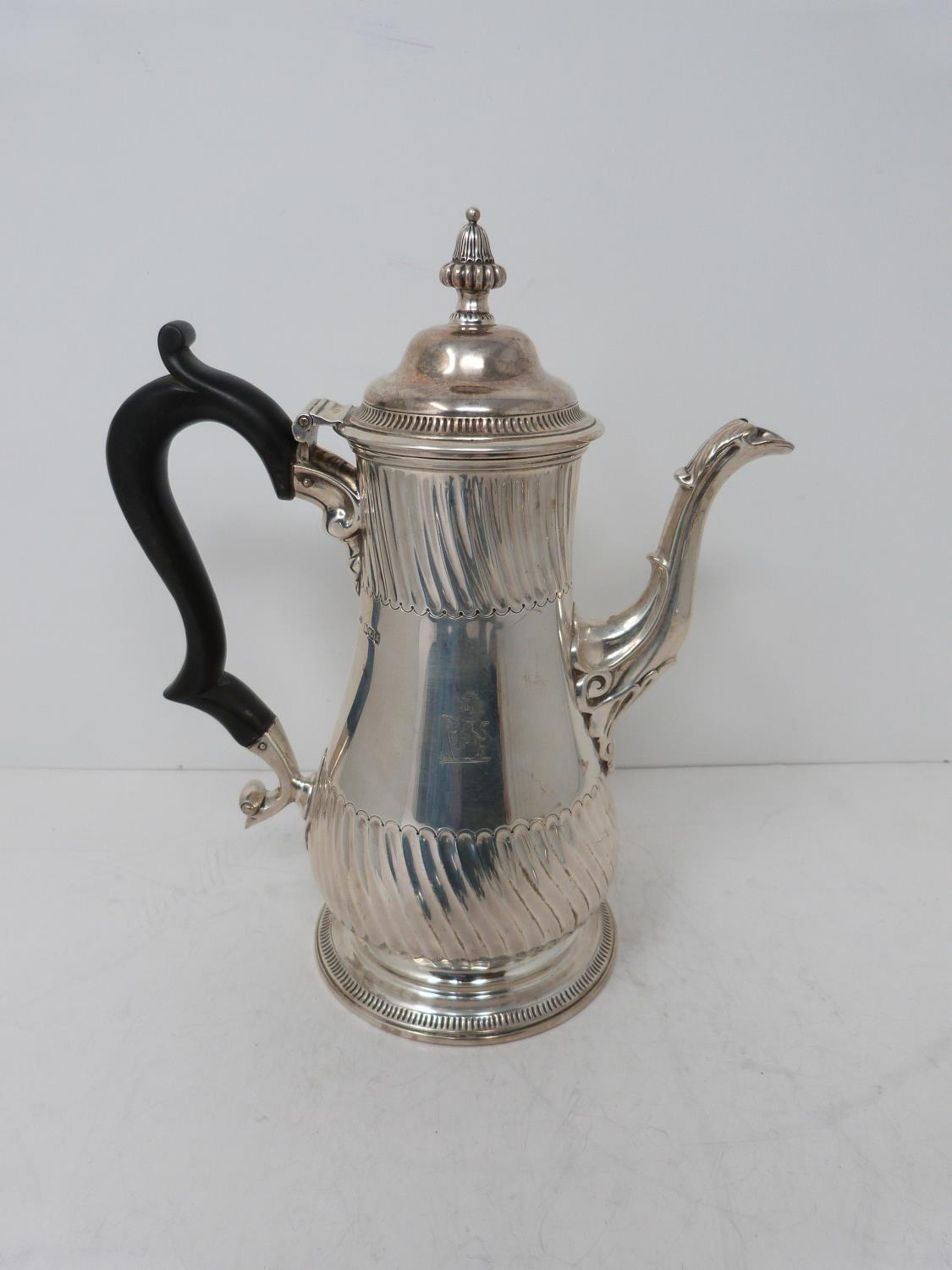 A Victorian sterling sliver coffee pot, with armorial crest on front, ebony handle and scrolling