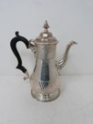 A Victorian sterling sliver coffee pot, with armorial crest on front, ebony handle and scrolling