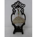 An early 20th century jade pendant on carved wooden stand. Pale celadon jade pendant in the form