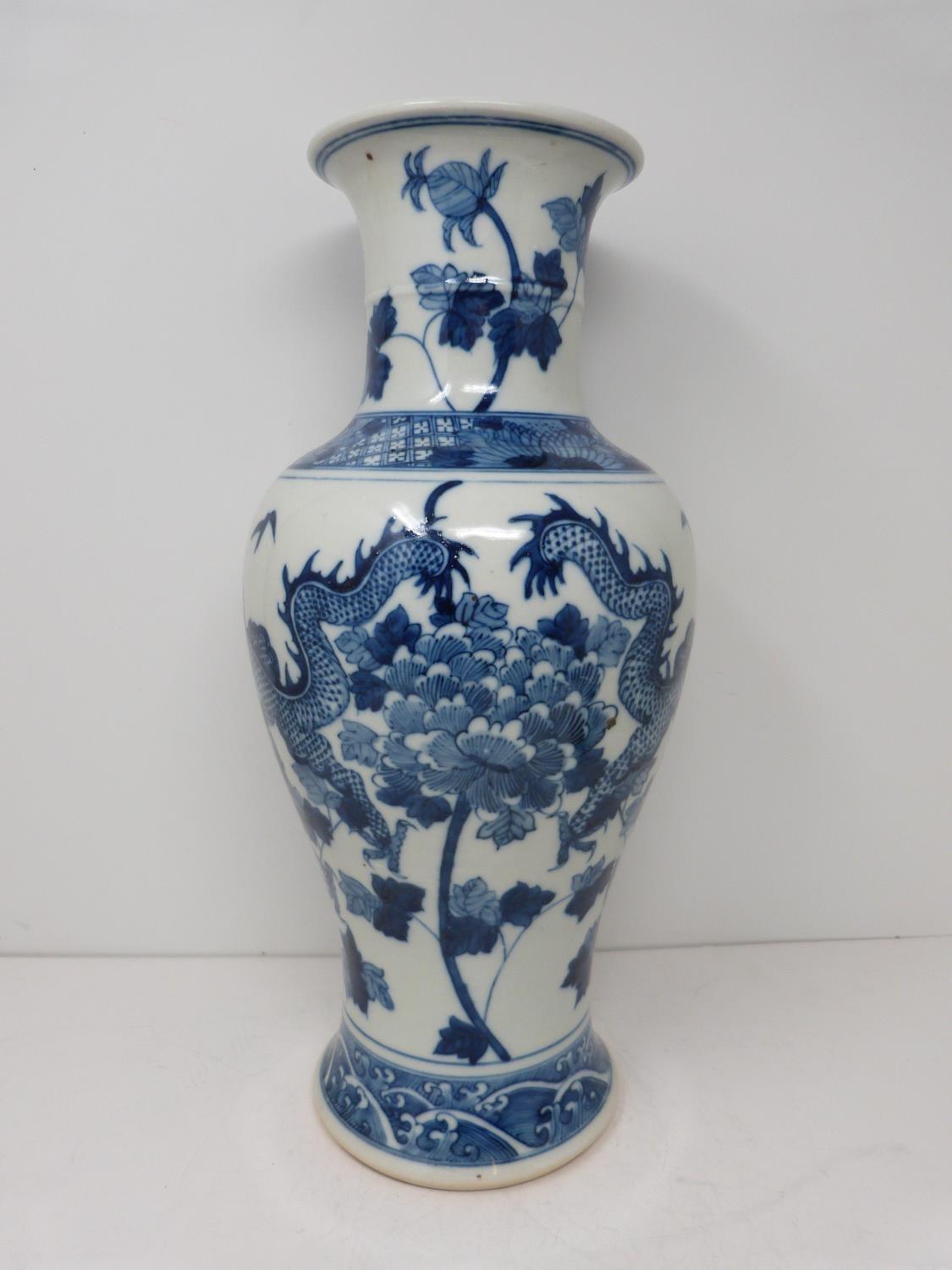 A Kangxi style blue and white baluster dragon vase with floral motifs. Four character mark to - Image 3 of 5