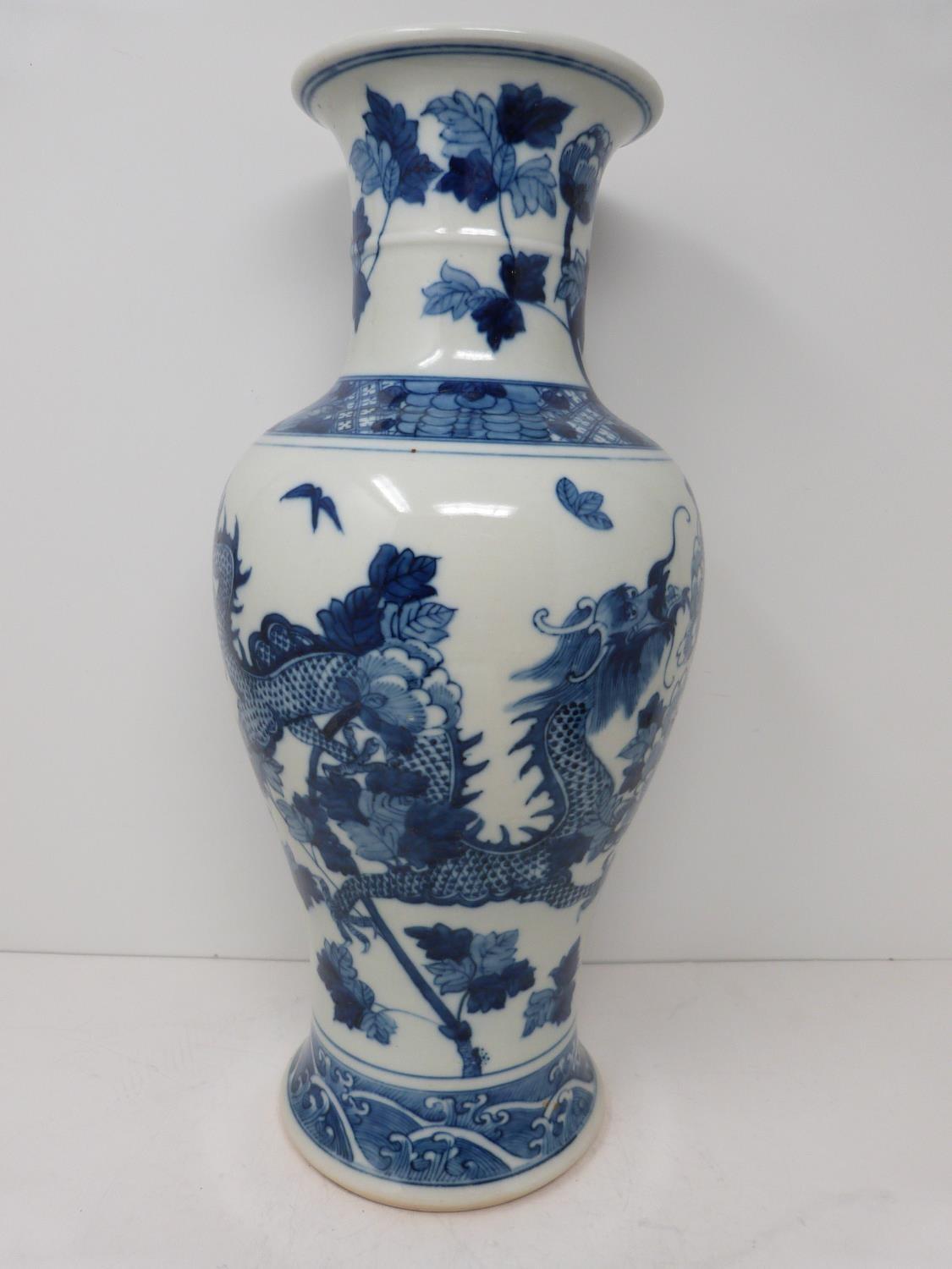 A Kangxi style blue and white baluster dragon vase with floral motifs. Four character mark to - Image 2 of 5