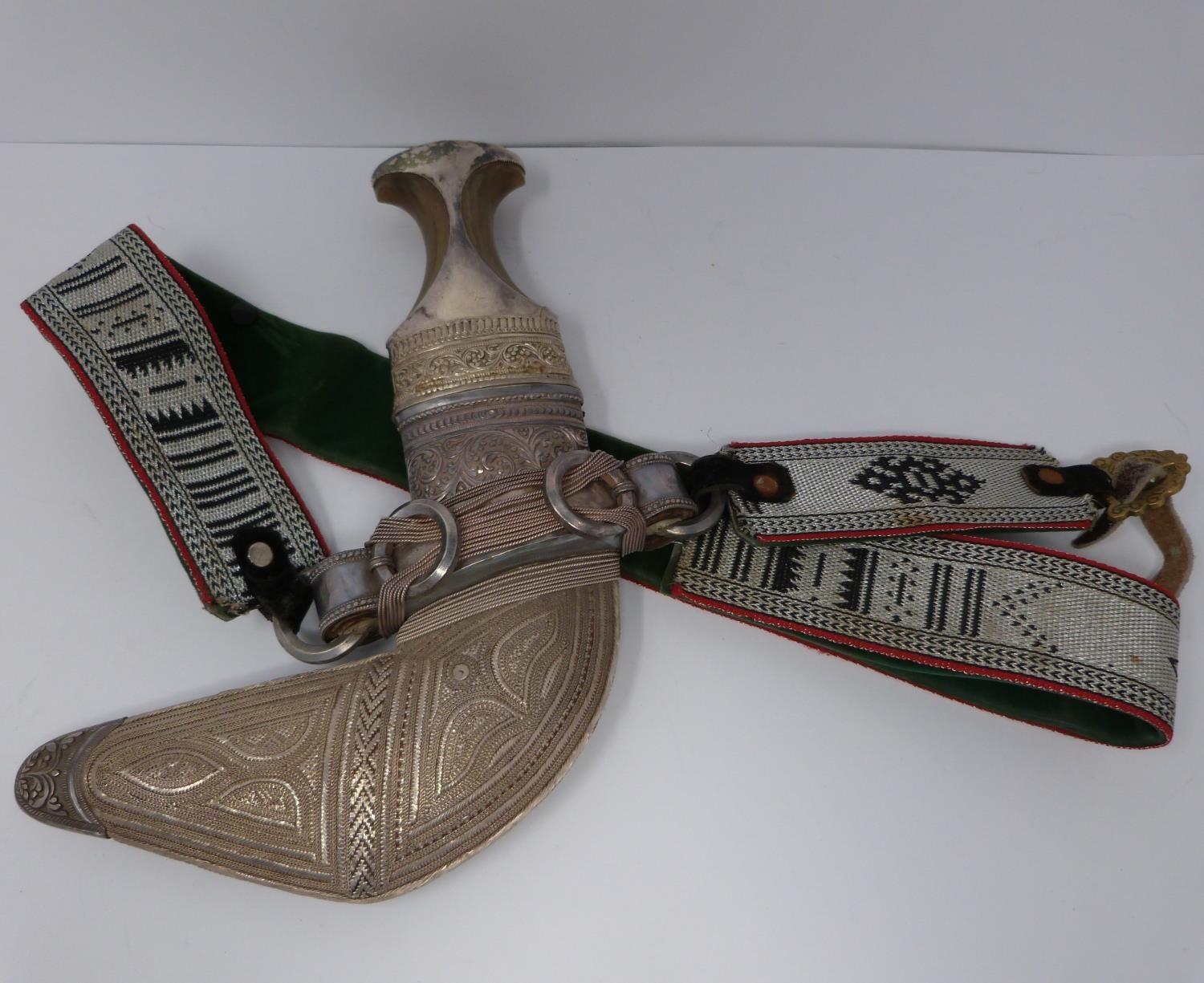 A 20th century silver Omani Khanjar with colourful and silver thread woven strap, covered with