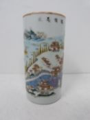 A Famille rose style cylindrical vase/ brush pot with landscape decoration and Chinese characters.