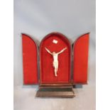 A 19th century ivory corpus christi in a arched, red velvet lined, tooled leather triptych case.