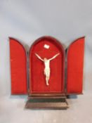 A 19th century ivory corpus christi in a arched, red velvet lined, tooled leather triptych case.