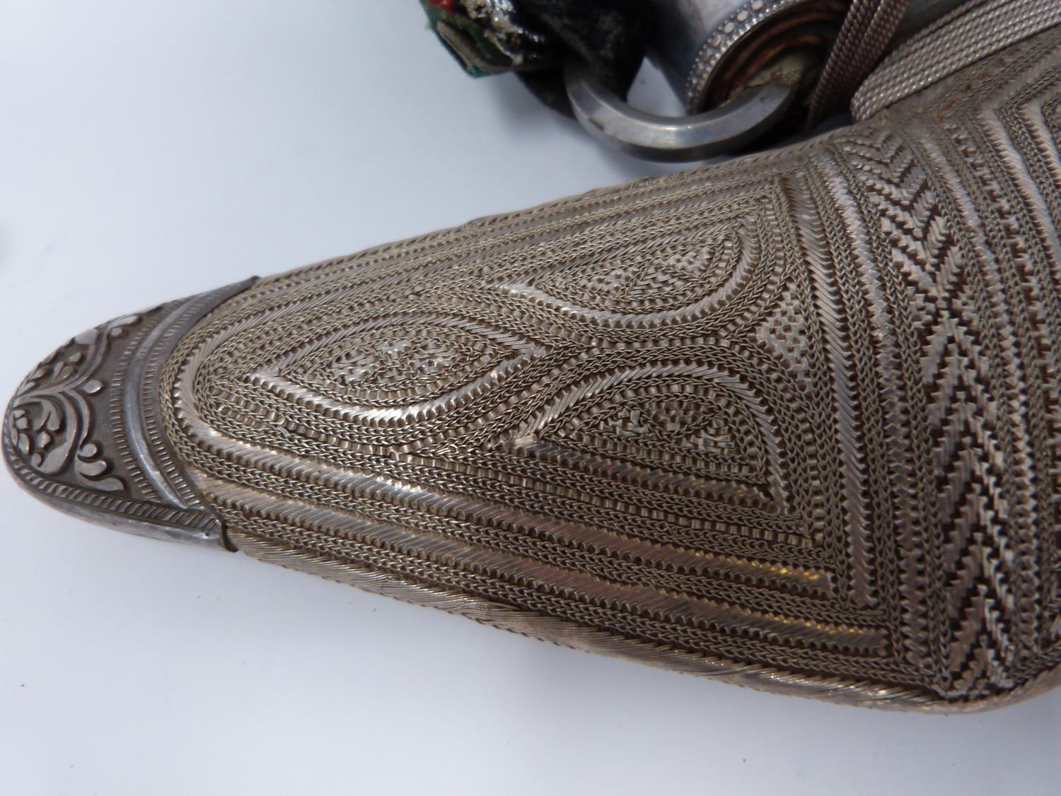 A 20th century silver Omani Khanjar with colourful and silver thread woven strap, covered with - Image 6 of 12