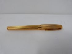 A gold plated Dupont fountain pen with two colour 18k nib. Engine turned decoration to the pen.